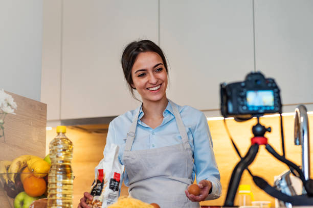 istock Woman food vlogger baking in kitchen and filming on camera 1135281989