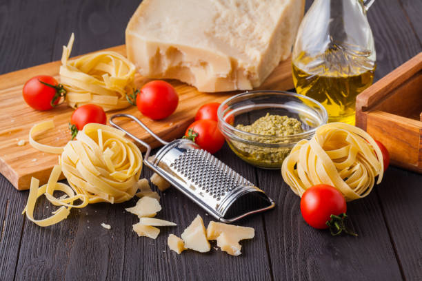 istock Ingredients ready for cooking delicious italian dinner for two: pasta, garlic, cherry tomatoes, red and green pepper, cheese 1135282001