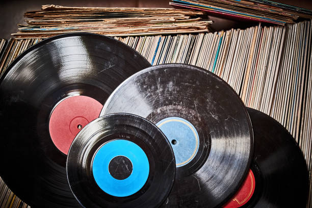 Vinyl record in front of a collection of albums, vintage process. - fotografia de stock