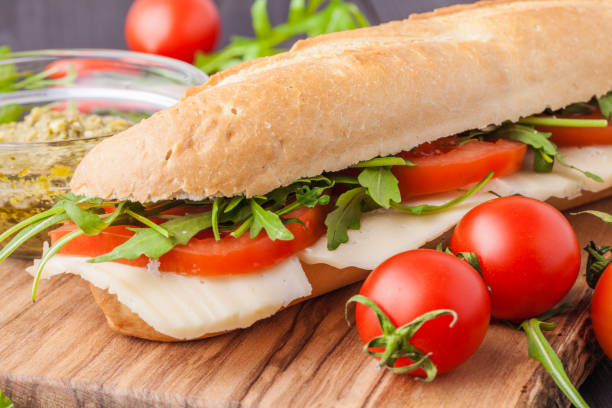 istock Toasted panini with ham, cheese and arugula sandwich on cutting board 1135282784