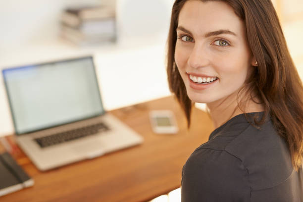 Shot of a young woman using a laptop while working from home