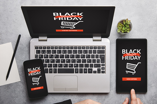 Black friday concept on laptop, tablet and smartphone screen over gray table. All screen content is designed by me. Flat lay