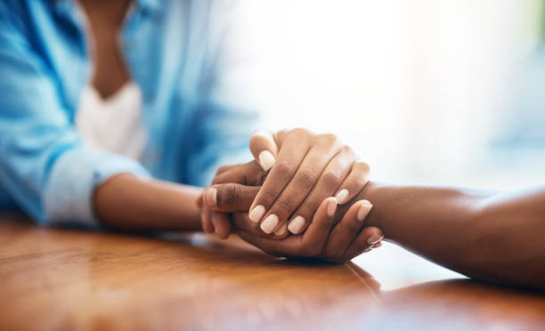 You have my full support Closeup shot of two unrecognizable people holding hands in comfort at home forgiveness photos stock pictures, royalty-free photos & images