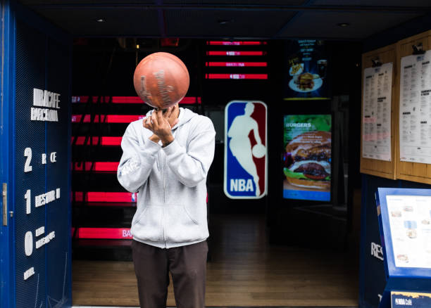 nba café barcelona in barcelona. fit man spinnt einen basketball. - streetball basketball sport men stock-fotos und bilder