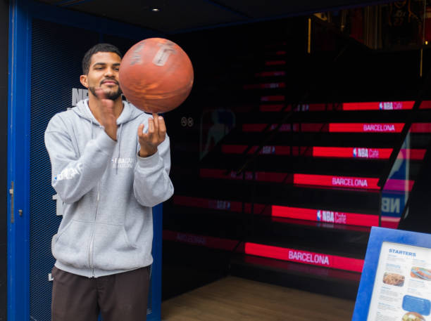 nba café barcelona a barcellona. uomo in forma che gira un basket. - nba foto e immagini stock