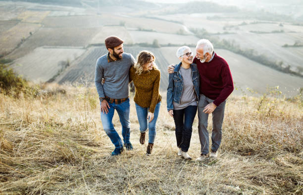 istock Happy couples talking while walking embraced up the hill. 1135288998