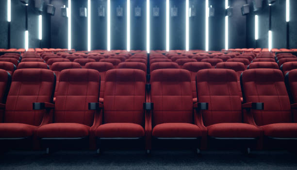 Cinema hall with blank screen and empty seats. Modern design with striking lighting, neon lighting. Audio system on the walls. Cinema hall without people. White screen with copy space, 3D illustration