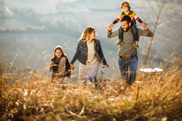 istock Carefree parents having fun while running with their kids on a field. 1135289364