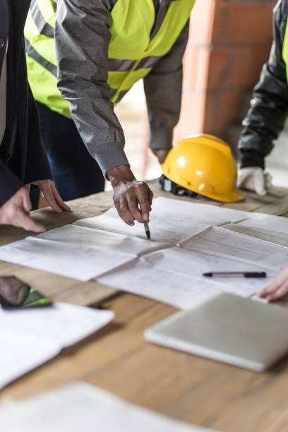 Construction worker Housing projects - blueprint - finger pointing african american architecture stock pictures, royalty-free photos & images