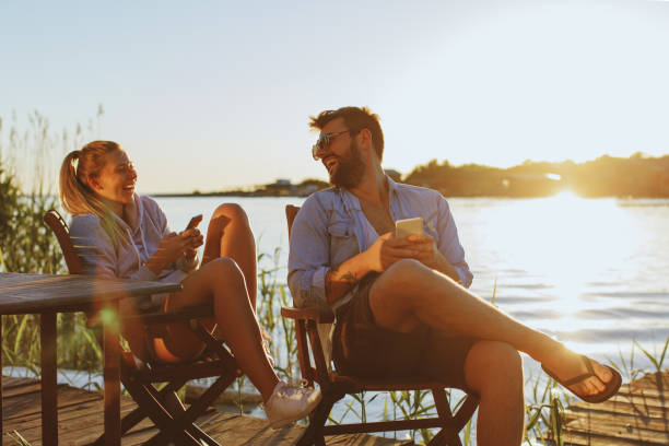 istock Young woman and man using smartphone by the river 1135289448