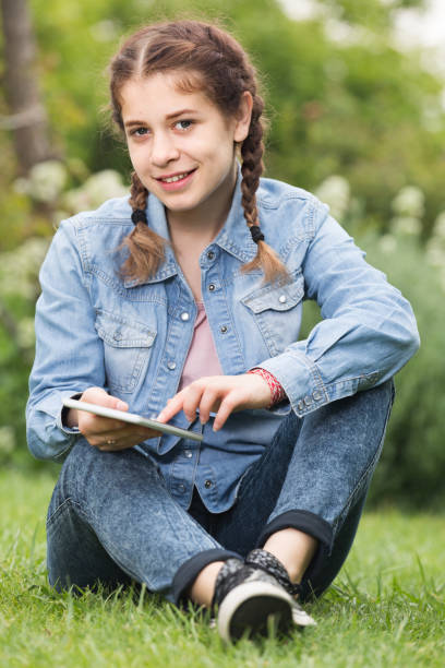 istock young girl using digital tablet while lying in green spring  garden 1135290943