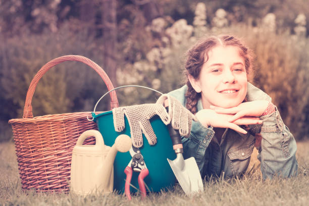 istock female with gardening tools while lying in park 1135290953