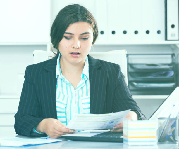 istock Office manager woman is reading documents about the transaction 1135291194