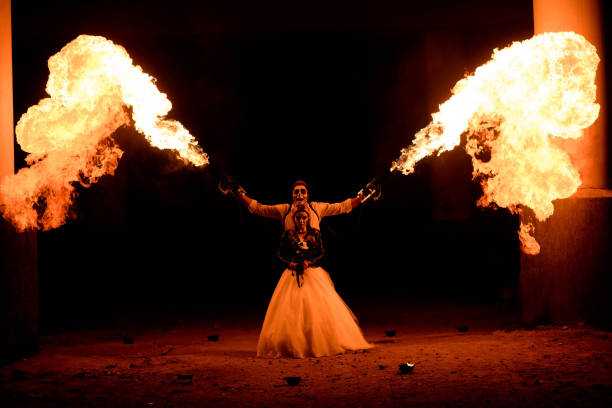 istock Halloween couple standing with flamethrower in hands. big fire 1135291236