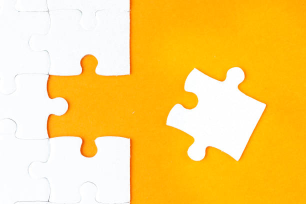 istock Last jigsaw puzzle pieces on orange background 1135292438