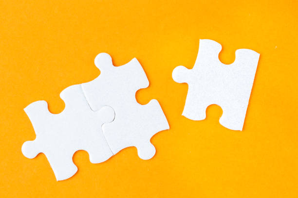 istock Three connected jigsaw puzzle pieces on orange background 1135292458