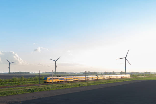 Intercity train of the Dutch Railways driving in springtime landscape with wind turbines Intercity train of the Dutch Railways driving in springtime landscape with wind turbines in the background intercity train photos stock pictures, royalty-free photos & images