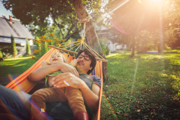 família que aprecia a mola/dia de verão no hammock - hammock comfortable lifestyles relaxation - fotografias e filmes do acervo