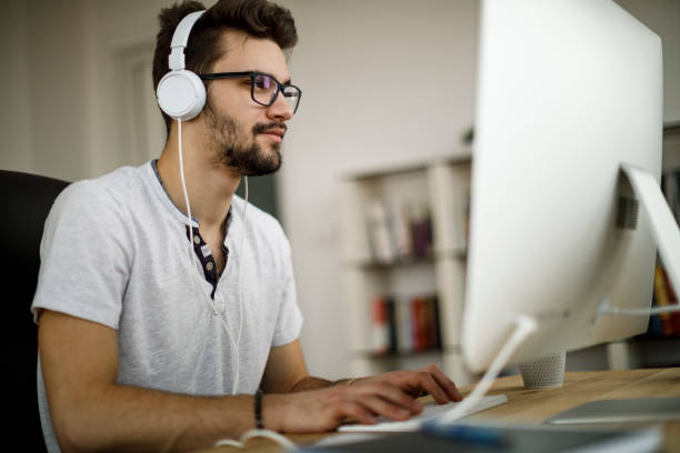 istock Young man enjoying music and working on his computer 1135301132