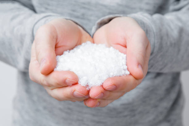 White hail with fresh snow slowly melting in man hands. Closeup. Front view.