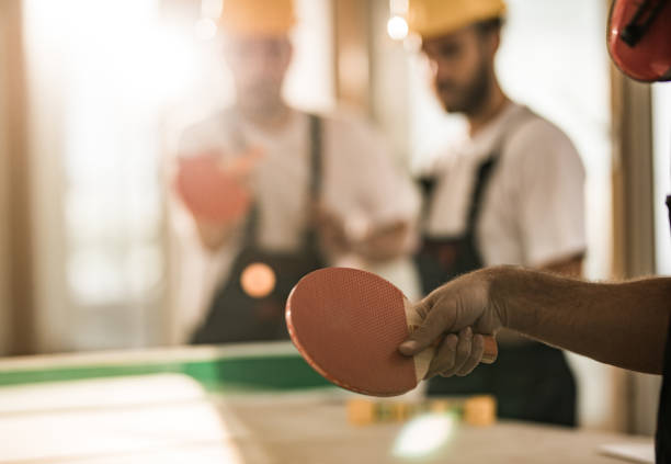 istock Close up of workers playing table tennis on a break at construction site. 1135304738