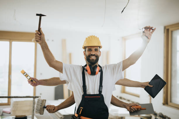 Happy multi-tasking construction worker in renovating apartment.