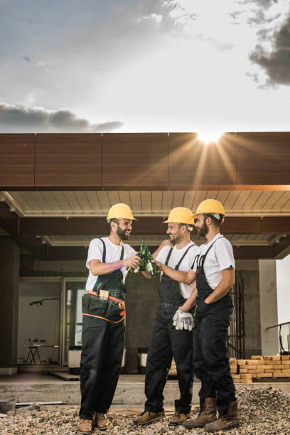 istock Team of happy construction workers toasting with beer on a terrace. 1135306012