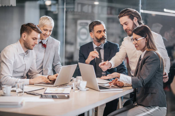 istock Group of business people talking while working on laptop in the office. 1135306680