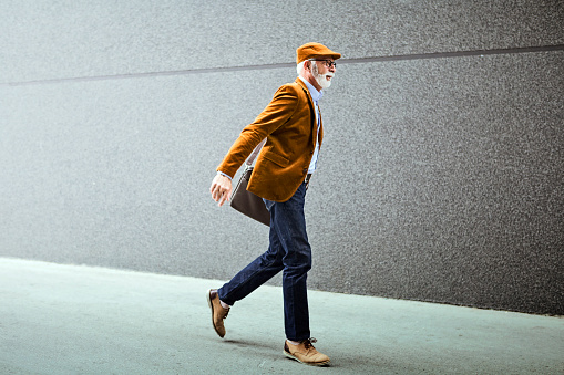 Fashionable Senior Man Outdoors wearing laptop bag