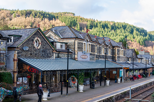 Betws y Coed, UK - Feb 12, 2019: People standing on the platform of Betws y Coed railway station on a bright February day.
