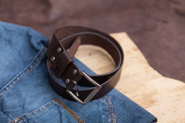istock Brown leather belt with jeans textile on wood 1135307804