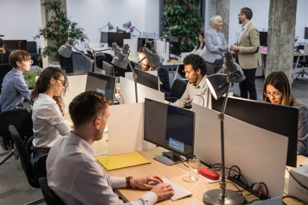 istock Large group of graphic designers working on computers at corporate office. 1135307979