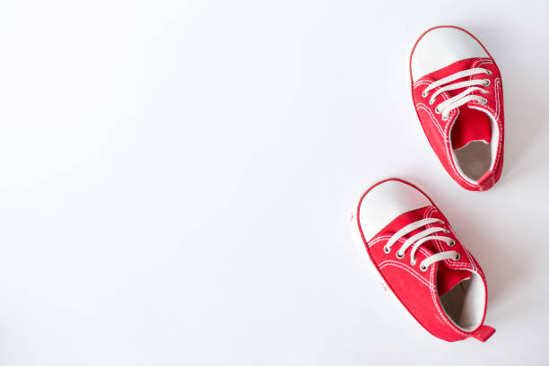 istock Cute red small sized canvas shoes top view on white background with copyspace 1135308040