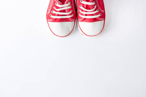 istock Cute red small sized canvas shoes top view on white background with copyspace 1135308106