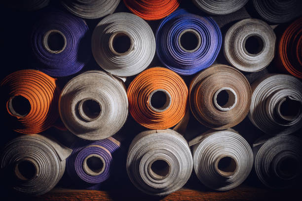 molti rotoli tessili di colori blu, bianco e arancione accatastati uno sopra l'altro - industria della moda foto e immagini stock