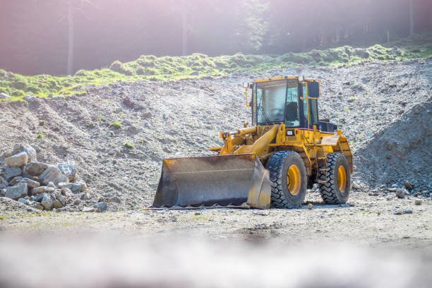 escavatore gommata gialla in una cava - loading wheel mining equipment foto e immagini stock