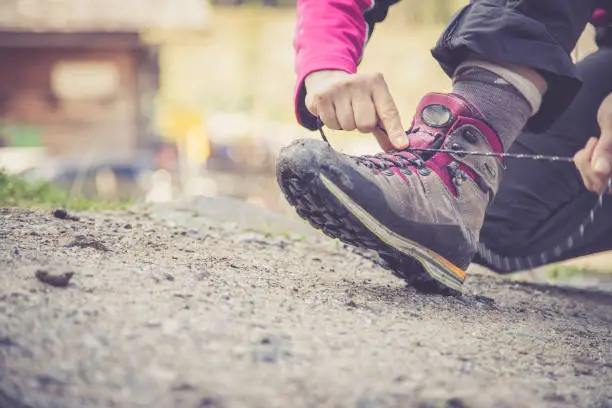 Close up of hiking boots, woman is tying them to prepare for wander