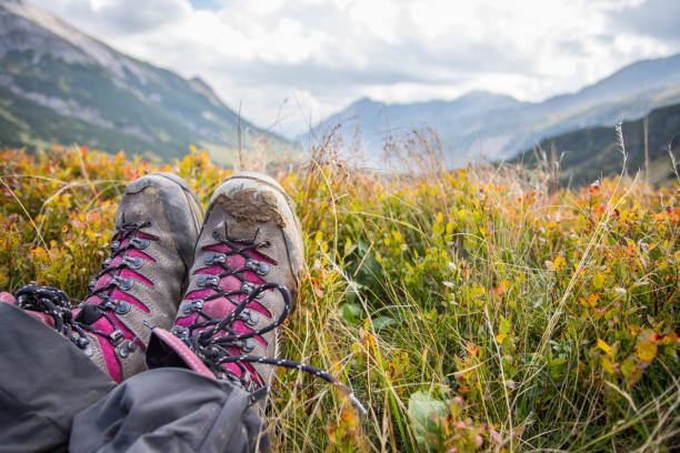 Cut out of a woman in hiking boots who is enjoying the idyllic mountain landscape