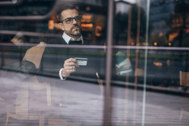 istock Handsome man holding credit card in cafe 1135314609