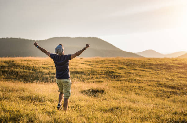 istock Ecstatic young man celebrating life on a beautiful meadow during sunset. 1135315113