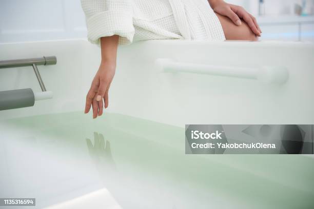 Close Up Lady Touch Water In Bath Tub Stock Photo - Download Image Now - Bathtub, Heat - Temperature, Hand