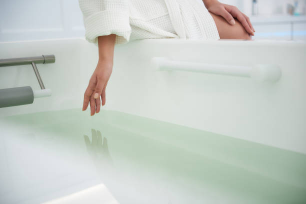 крупным планом леди коснуться воды в ванной - bathtub asian ethnicity women female стоковые фото и изображения