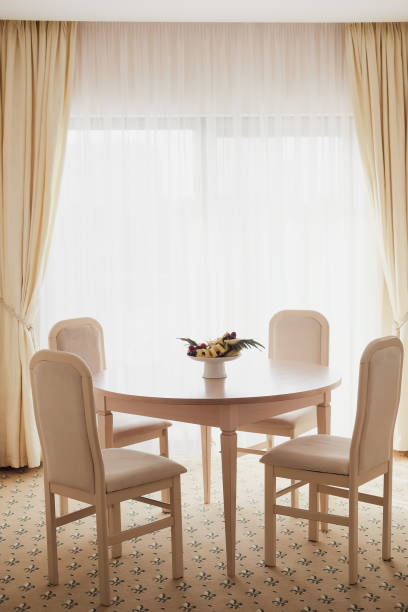 istock Bright spacious dining room with wooden  table, four chairs and big window 1135317541