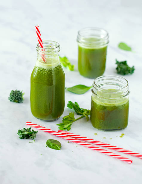 istock Fresh green juice with red striped drinking straw 1135319324