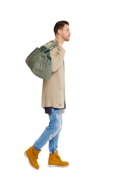 istock back view of walking  man  with green bag. 1135320861