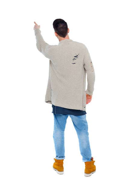 istock Back view of a stylish man in a knitted sweater points his hand 1135322596