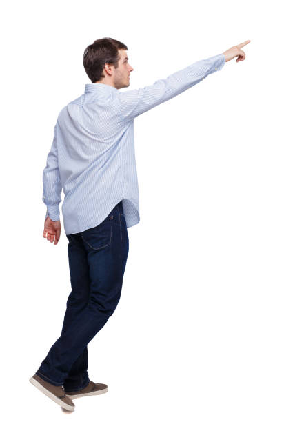 istock Back view of a man walking with a pointing hand. 1135322609