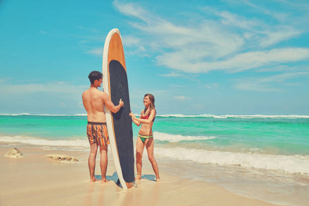 istock Couple with surfboard enjoying on the tropical beach. 1135324727