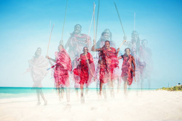 Masai Mara, Kenya, 1965. Group of young Massai warriors with their traditional weapons spears and club.