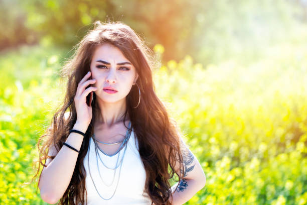 sad woman speaking by phone in nature
